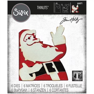 May include: A red and white die cut of Santa Claus with a white beard and black belt. The die cut is part of a set of 6 dies for crafting. The image also includes the text "THINLITS®" and "Jim Holtz".