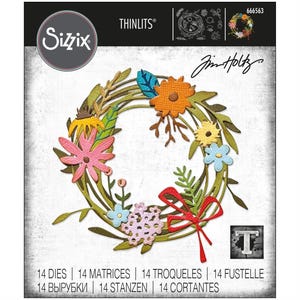 May include: A set of 14 metal dies for crafting, featuring a floral wreath design with a red bow. The dies are designed to be used with a die-cutting machine. The package includes the text "THINLITS®" and "Jim Holtz".