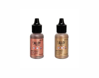 May include: Two small bottles of metallic paint with black caps. The bottles are labeled "Alloy" with the words "Mined" and "Statue" below. Each bottle contains 3 fl oz (88.7 ml) of paint. The bottles have a copper and gold color.
