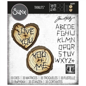 May include: A set of 33 metal dies for crafting, featuring a woodgrain heart with the words "Love You" and a circle with the words "You Me". The dies also include the alphabet in a handwritten style.