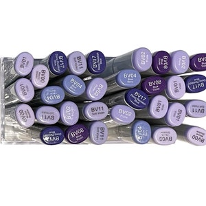 May include: A collection of purple, blue, and lavender colored markers with different shades and names. The markers are arranged in a clear plastic container.