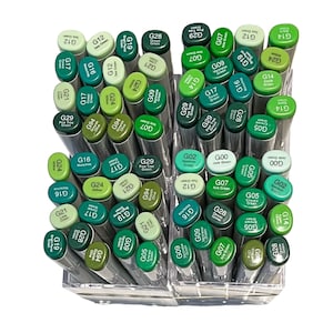 May include: A collection of green alcohol markers in a clear plastic container. The markers are arranged in rows and columns, and the caps are labeled with numbers and letters.