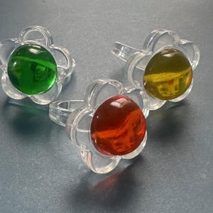 Lote divertido de tres anillos de flores de plástico translúcido naranja, amarillo, verde y transparente de estilo pop art de los años 60, talla 6