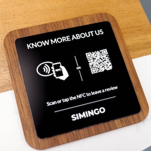 May include: A square sign with a wood-effect border and a black centre. White text reads "KNOW MORE ABOUT US" and "Scan or tap the NFC to leave a review." Includes a QR code and NFC symbol. The brand name "SIMINGO" is at the bottom.