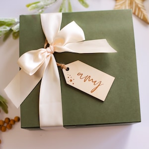 May include: A green gift box with a cream satin ribbon and a wooden gift tag that says "amy".