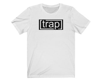 May include: White t-shirt with a black square containing the word "trap" in white letters.