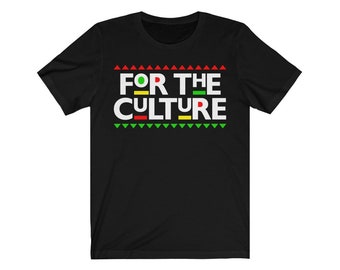 May include: Black t-shirt with the text "FOR THE CULTURE" in white block letters. The design includes green, red, and yellow accents. The shirt has a crew neck and short sleeves.