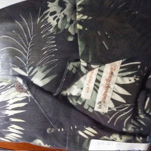 May include: A black button-down shirt with a tropical leaf print. The shirt has a label that reads "Original Fit" and "Tommy Bahama".