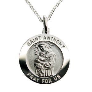 May include: Silver Saint Anthony medal pendant with a detailed image of Saint Anthony holding a baby Jesus. The medal is round and has the words "Saint Anthony Pray For Us" inscribed around the edge.