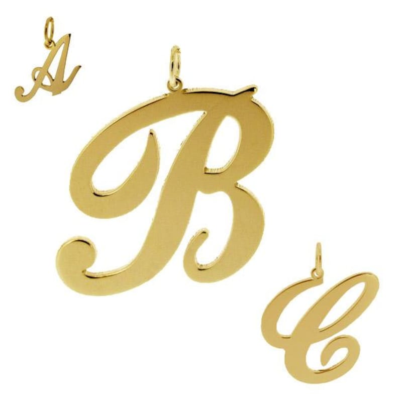 May include: Three gold-colored cursive letter charms, A, B, and C. The charms are designed to be worn as pendants on a necklace or bracelet.