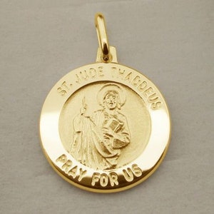 May include: Gold-toned pendant featuring a religious image of Saint Jude Thaddeus. The pendant is round and has the words "St. Jude Thaddeus" and "Pray for Us" inscribed around the image.