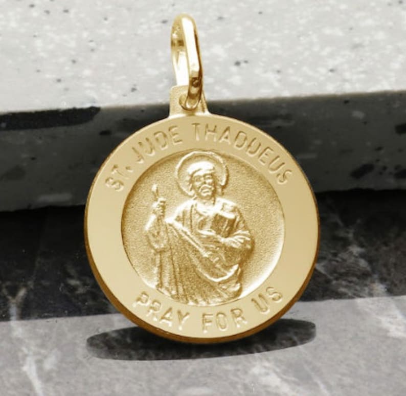 May include: Gold-toned St. Jude Thaddeus medal pendant with a raised image of the saint holding a book and a staff. The medal is inscribed with "St. Jude Thaddeus" and "Pray for Us".