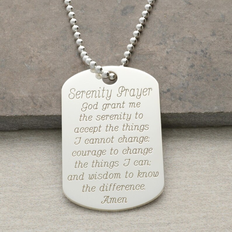 Puede incluir: Collar con placa de identificaci&oacute;n de plata con la oraci&oacute;n de la serenidad grabada. La oraci&oacute;n dice: "Dios, conc&eacute;deme la serenidad para aceptar las cosas que no puedo cambiar, el valor para cambiar las que s&iacute; puedo, y la sabidur&iacute;a para conocer la diferencia. Am&eacute;n."