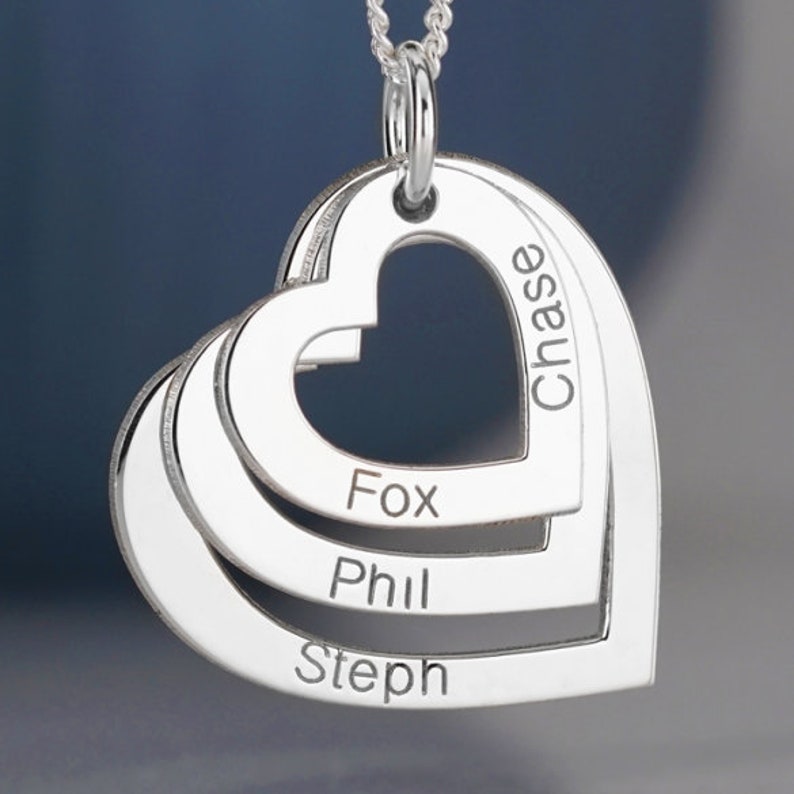 Puede incluir: Collar de plata con cuatro colgantes de coraz&oacute;n entrelazados. Los corazones est&aacute;n grabados con los nombres Chase, Fox, Phil y Steph.