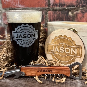 Puede incluir: Un set de regalo personalizado para un padrino de boda con una caja de madera, un vaso de cerveza, un posavasos y un abridor de botellas. El vaso y el posavasos est&aacute;n grabados con el nombre "Jason" y la fecha "7.16.2023". El abridor de botellas tambi&eacute;n est&aacute; grabado con el nombre "Jason".