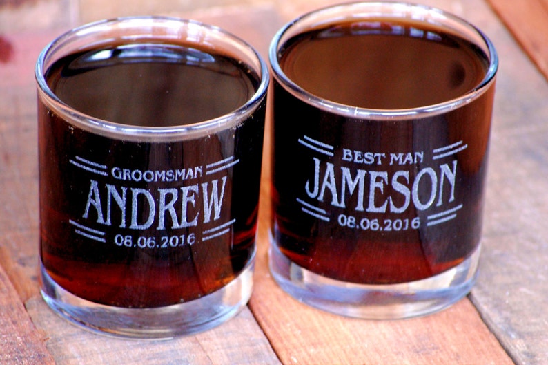 May include: Two clear glass tumblers with engraved text. The tumbler on the left says "Groomsman Andrew 08.06.2016". The tumbler on the right says "Best Man Jameson 08.06.2016".