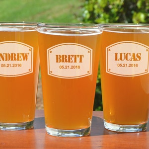 Puede incluir: Tres vasos de cerveza personalizados con los nombres Andrew, Brett y Lucas, y la fecha 05.21.2016 grabada en cada vaso.