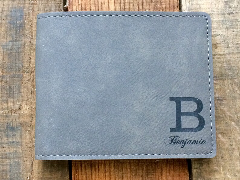 May include: A gray leather wallet with a large black letter "B" and the name "Benjamin" engraved on the front.