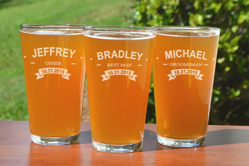Puede incluir: Tres jarras de cerveza de vidrio transparente con texto personalizado y fechas. Las jarras est&aacute;n llenas de una bebida de color &aacute;mbar claro. El texto en las jarras dice "Jeffrey - Usher - 10.31.2015", "Bradley - Best Man - 10.31.2015" y "Michael - Groomsman - 10.31.2015".
