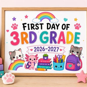 Puede incluir: Un cartel enmarcado con el texto First Day of 3rd Grade 2026-2027, que incluye un arcoíris, dos gatos, un ajolote, una pila de libros con las frases Be Kind, Dream Big, You Got This, un lápiz y una mochila morada con útiles escolares.