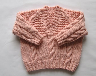 Pink cabled baby sweater. Size: up to 1 month, 10 lbs (4.5kg) 56cm height.