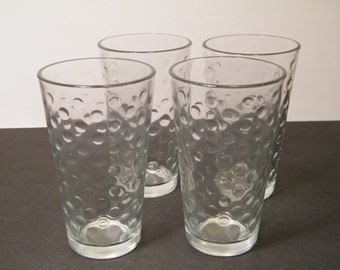 May include: Set of four clear glass drinking glasses with a textured, bubbled surface.