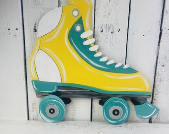 May include: A yellow and green roller skate with white laces and wheels. The skate is painted on wood and has a vintage look.