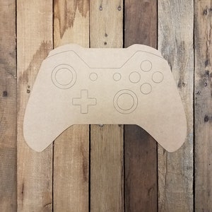 May include: A brown wooden cutout of a video game controller. The controller has a plus sign, a circle, and four smaller circles.
