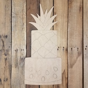 May include: Unfinished wooden cutout of a pineapple with a watermelon slice underneath. The pineapple has a detailed design of the fruit's skin and leaves. The watermelon slice has a simple design of seeds.
