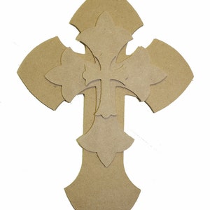 May include: A wooden cross with a decorative design. The cross is made of multiple layers of wood, creating a layered effect. The cross is a light brown color.