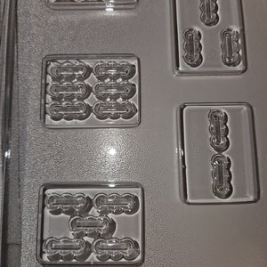 May include: Clear plastic candy mold with various shaped cavities. The mold has rectangular and square sections with cloud-like and oblong shapes. The text "LIFE OF THE PARTY" is embossed at the bottom of the mold.