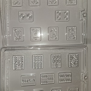May include: Clear plastic mold with multiple rectangular cavities, each featuring a different design. The designs include Chinese characters and various patterns, likely for creating decorative items. The mold is labeled "LIFE OF THE PARTY M 269 - A".