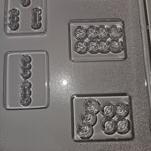 May include: Clear plastic candy mold with various shaped cavities. The mold includes rectangular and circular shapes, with the text "THE PARTY M 269 - A" at the bottom. The cavities are designed for creating candies or chocolates.