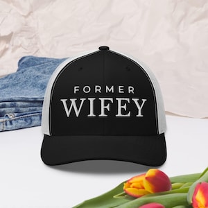 Può includere: Cappellino da camionista nero e bianco con la scritta ricamata "FORMER WIFEY". Il cappellino ha visiera e corona nere, retro in rete bianca e visiera curva. Un accessorio casual.