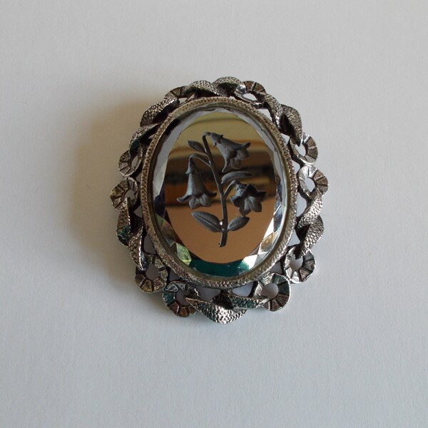 Tono de plata vintage y flor de intaglio tallada en negro en broche de vidrio