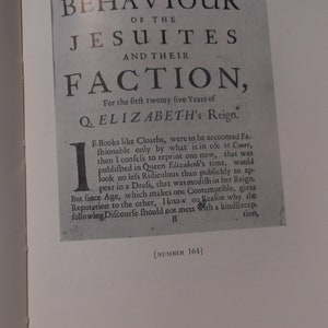 Può includere: Una pagina di un libro intitolato "Comportamento dei Gesuiti e della loro fazione" stampato in bianco e nero. Il testo tratta del regno della regina Elisabetta I e della pubblicazione di libri durante il suo regno.