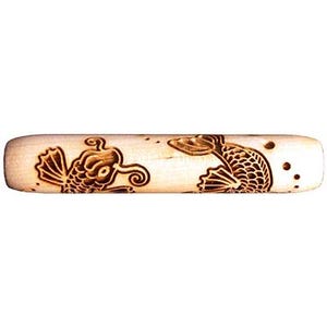 May include: A wooden rolling pin with a carved design of two koi fish. The fish are facing each other and have detailed scales.