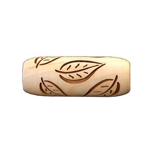 May include: A wooden rolling pin with a leaf pattern carved into the surface. The rolling pin is light brown in colour and has a smooth, polished finish.