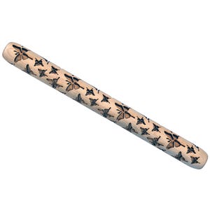 May include: A wooden rolling pin with a repeating butterfly pattern etched into the surface. The butterflies are dark brown against the light wood. The rolling pin is cylindrical and has rounded ends.