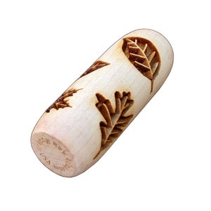 May include: A wooden rolling pin with a leaf design. The rolling pin is made in the USA and has the text "Made in USA" on the side.