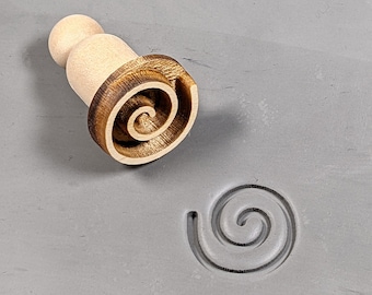 Op de afbeelding: Een houten deegroller met een spiraalvormig ontwerp. De deegroller wordt gebruikt om een spiraalvormig patroon in klei of deeg te maken.