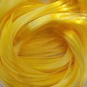 May include: A close-up of a bundle of bright yellow fiber optic strands. The strands are tightly wound together, creating a swirling pattern.
