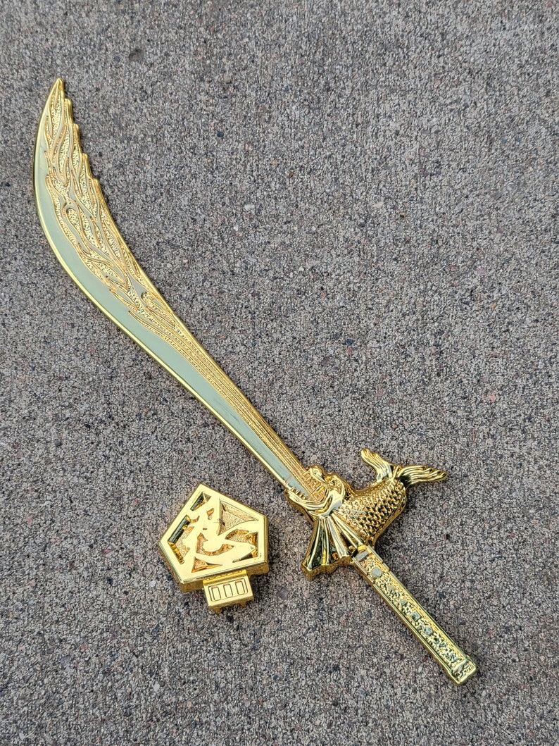 May include: A gold-colored sword with a decorative handle and a sheath with a Chinese character on it.