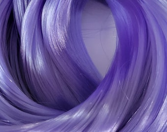 May include: A close-up of a bundle of soft, silky, lavender-colored yarn.