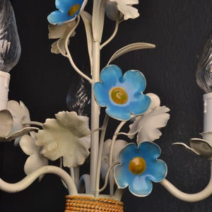 May include: White metal chandelier with blue flowers and leaves. The chandelier has a rope detail around the base.