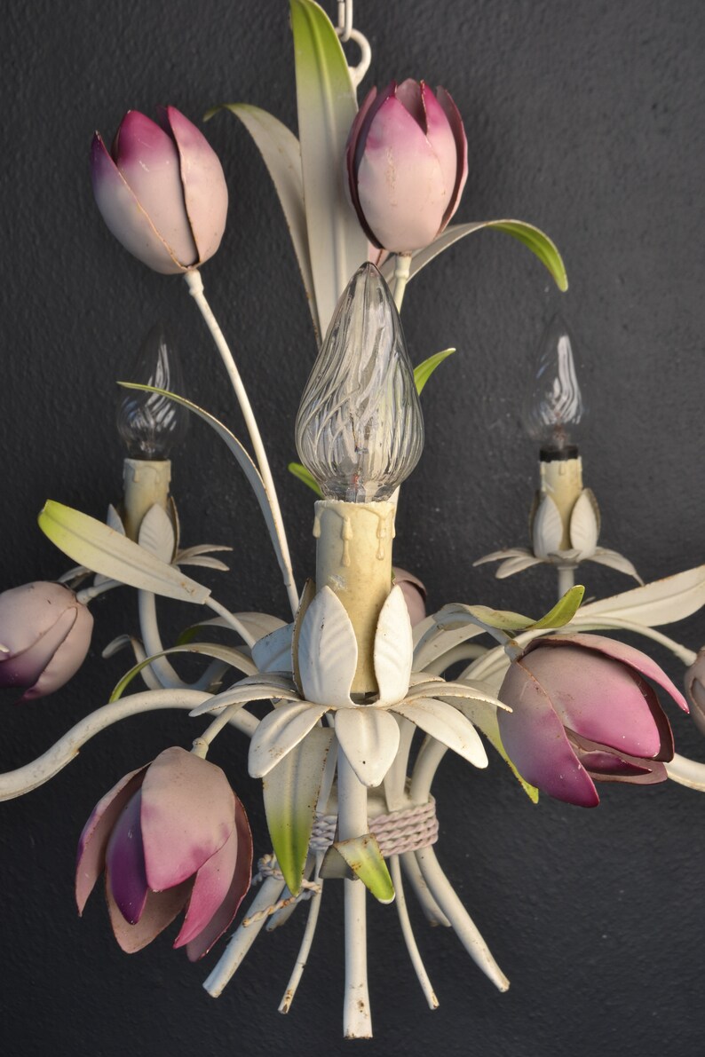 Pu&ograve; includere: Un lampadario in metallo bianco con fiori rosa a forma di tulipano e lampadine in vetro trasparente. Il lampadario ha uno stile vintage ed &egrave; perfetto per aggiungere un tocco di eleganza a qualsiasi stanza.