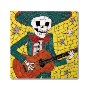 May include: A mosaic tile artwork depicting a skeleton wearing a sombrero and playing a guitar. The skeleton is wearing a green suit with a red bow tie. The background is yellow with stars.