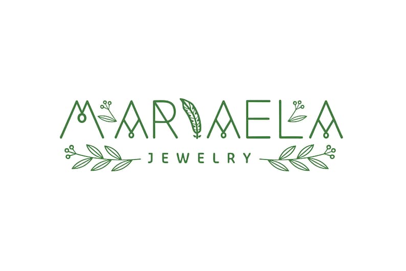 May include: A logo for a jewelry company called "MARIELA JEWELRY". The logo features the company name in a stylized font with a feather design in the middle. The name is flanked by leafy branches with berries.