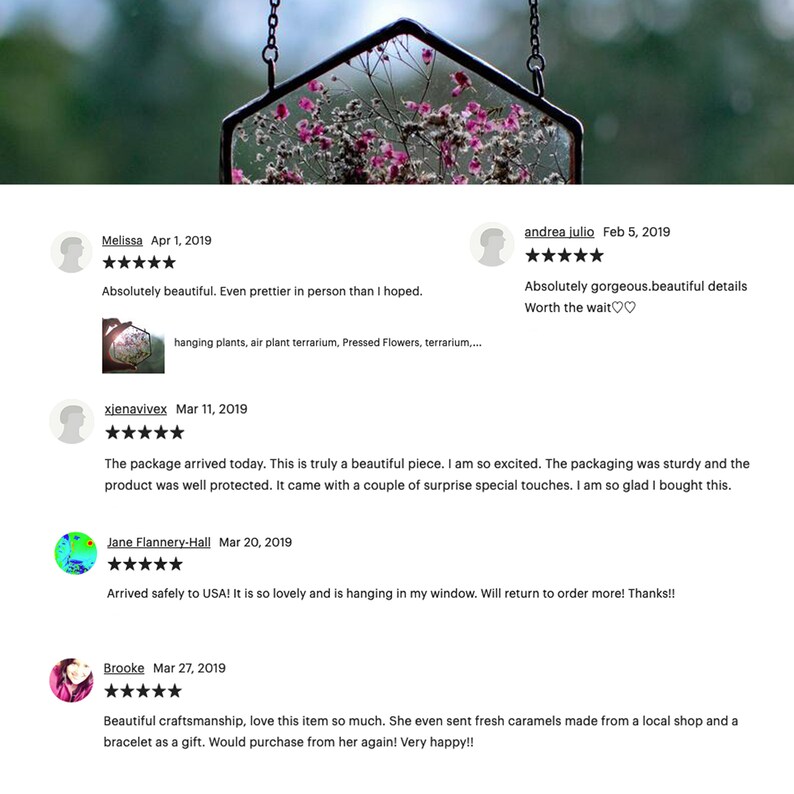May include: A glass terrarium with a hexagonal frame, hanging from a chain. The terrarium is filled with dried flowers and greenery. The terrarium is a popular home decor item and is often used to display plants, flowers, or other small objects.