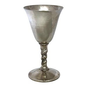 May include: A silver-colored metal goblet featuring a smooth, flared bowl and a textured, twisted stem design. The base is circular and flat, providing stability to the vessel. The surface has a polished, reflective finish throughout the entire piece.